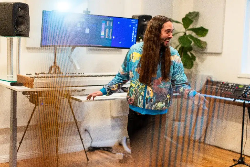 Luke F. Walton in the studio, at a keyboard with studio monitors and a mixing desk.
